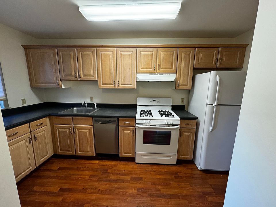 Kitchen area equipped with dishwasher, refrigerator, stove/oven. Gleaming hardwood floors.