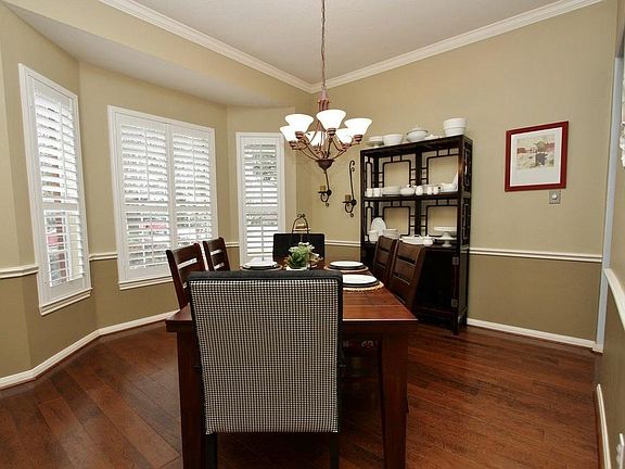 The Formal Dining Room offers a large dining space with extravagant colors offset by white chair rail and crown molding.