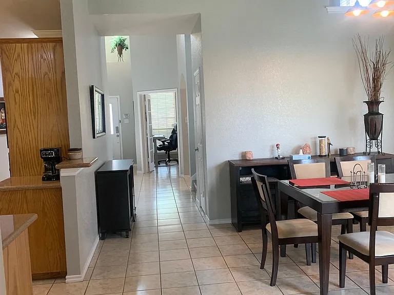 View from living area to front door of house.
Kitchen on left.
Dining area on right.
Stairs on right.
Hall to half bath on right.
Office on right.