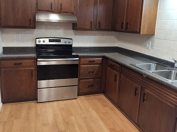 Ceramic tile surrounds countertop and cabinets. Hood vents out. Newer appliances and also a garbage disposal.