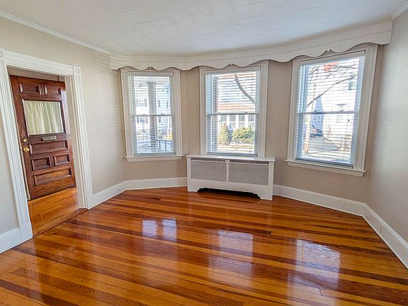 Bright and spacious living room with refinished hardwood floors and beautiful natural light