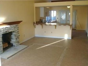 Spacious Living area with fireplace leading into the kitchen and covered patio
