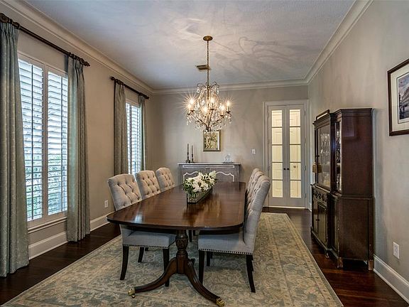 Spacious formal dining room, chandelier lighting, glass door to kitchen.
