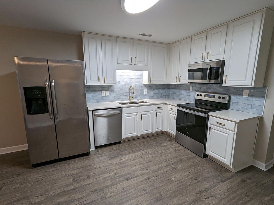 The kitchen features gold hardware, a gold faucet, a new tile backsplash, quartz countertops, stainless steel appliances, and more!