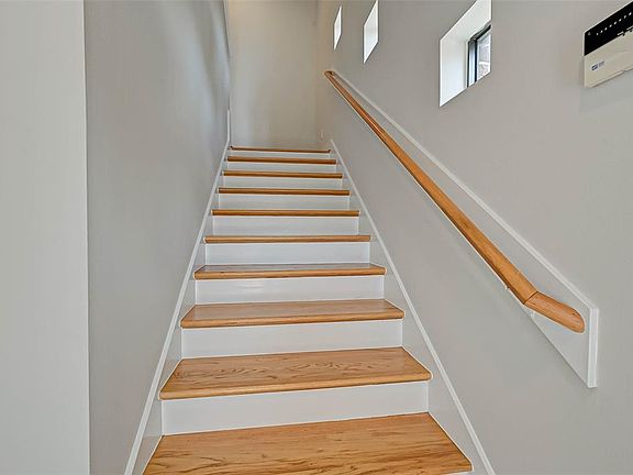 Entry with wood stairway treads and nice windows for natural light.