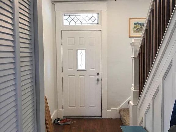 welcoming entryway with original stairs, hardwood and high ceilings