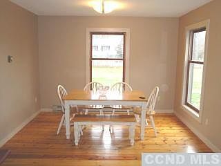 Open, light dining room with wide board floor.
