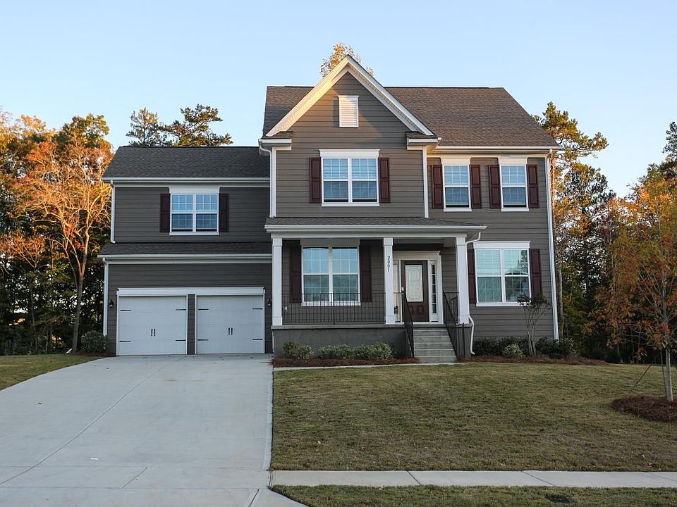 Front with large driveway and attached garage