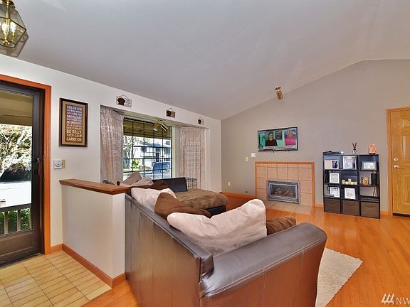 Front entrance opens to a great living space with large windows and gas fireplace. The door to the left is the garage and laundry area. Real hardwood flooring!