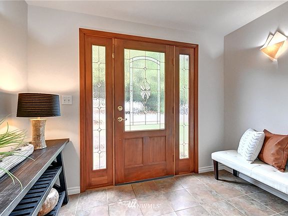 Light filled front entry with tile floors and attractive sconces.