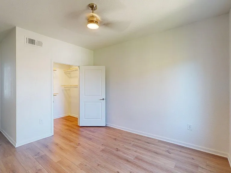 Spacious apartment Bedroom with wood-style flooring