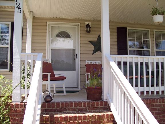 The shady front porch with room enough for chairs, chaise and swing.
