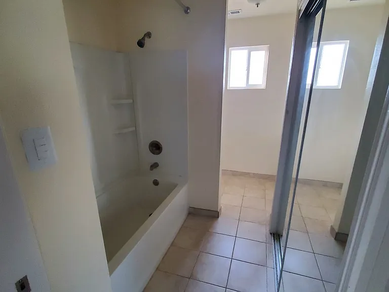 Guest Bathtub - Laundry behind sliding glass doors