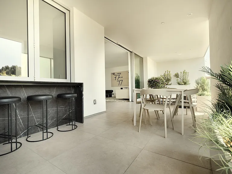 Expansive Outdoor Living with Seamless Indoor Integration _ Designed for both relaxation and entertaining, this covered terrace features a built-in bar, spacious dining area, and effortless connection to the interior living spaces.