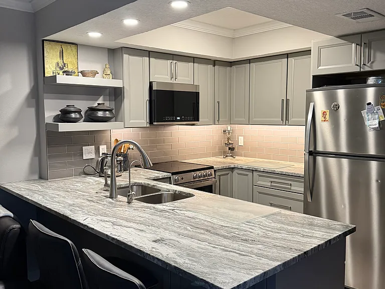 Kitchen with under-cabinet lighting and lots of overhead light, new cabinets, countertop and appliances
