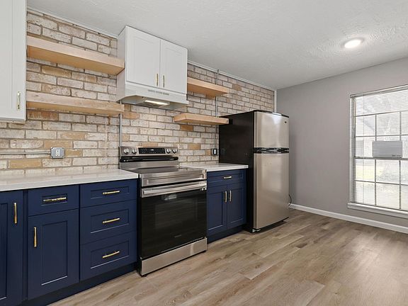 kitchen view of stove, fridge, window