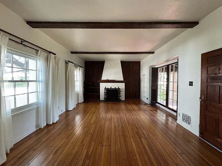 Living room - spacious living area with hardwood floor, exposed wood beams and fireplace.