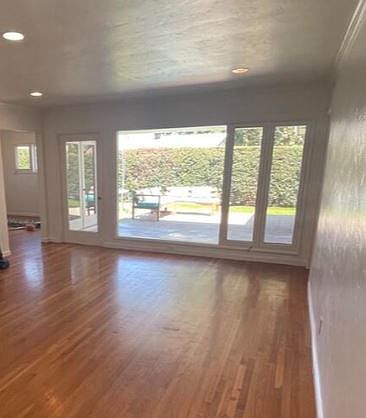 Large living room with hardwood floor and access to back patio and deck