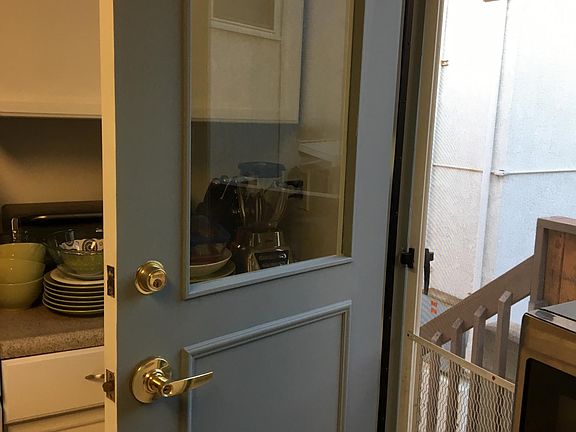 Freshly painted side door leading to deck and large shared backyard