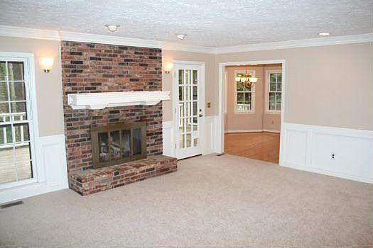 CARPETED FAMILY ROOM HAS BRICK FIREPLACE WITH GAS LOGS