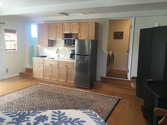 Bathroom entrance is at the left end of the cabinets. Entrance to shared laundry room is to the right of refrigerator. A small gas stove/oven has now been installed (not pictured)