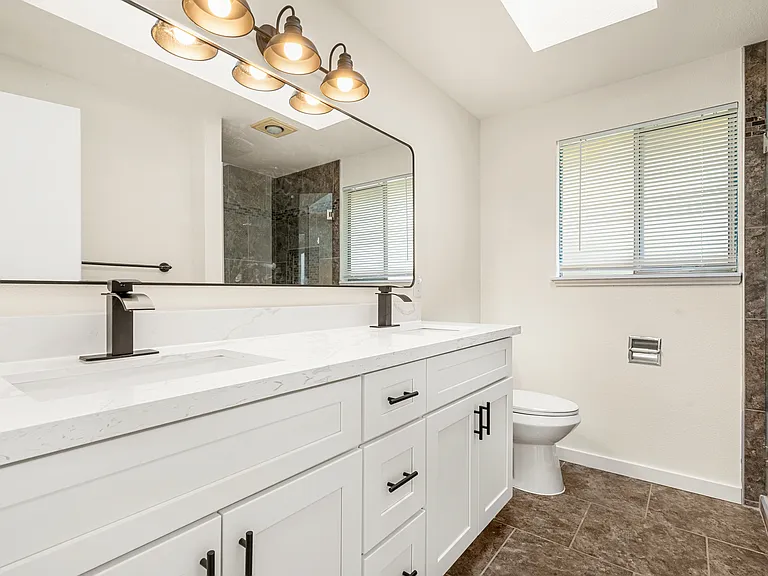 Great-sized master bedroom with a beautifully remodeled ensuite, showcasing a double-sink vanity and a sleek, modern shower.