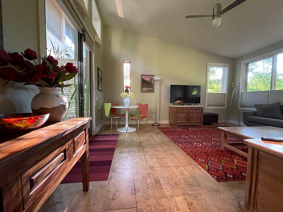 The living room with vaulted ceilings, a dining table, and Apple TV