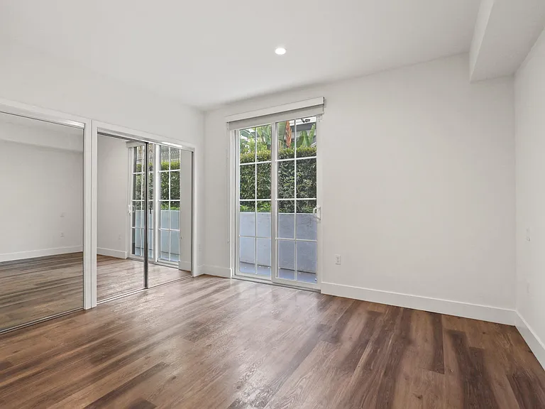 Bedroom with Double Mirrored Closets, Vinyl Flooring, and Balcony