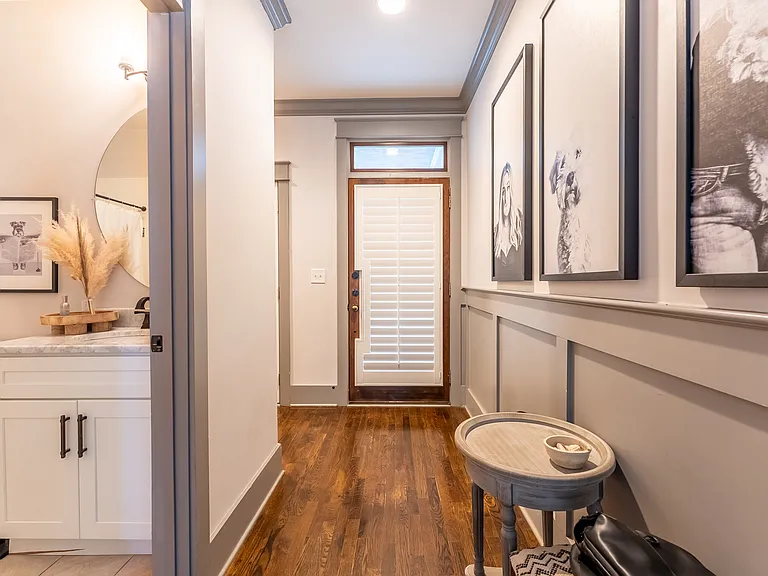 Hallway to front door, bathroom, laundry room and garage + stairs to 2nd floor