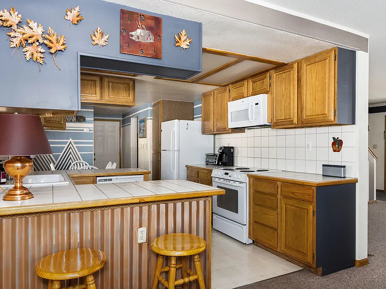 Downstairs fully stocked kitchen with island bar seating and TWO separate dining room tables perfect for large groups.