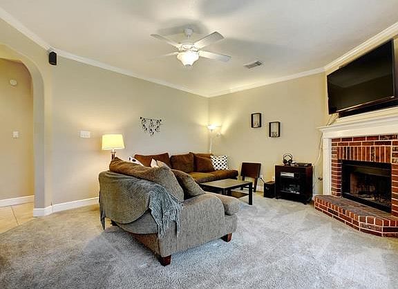 The living room features a corner fireplace with wooden mantel.