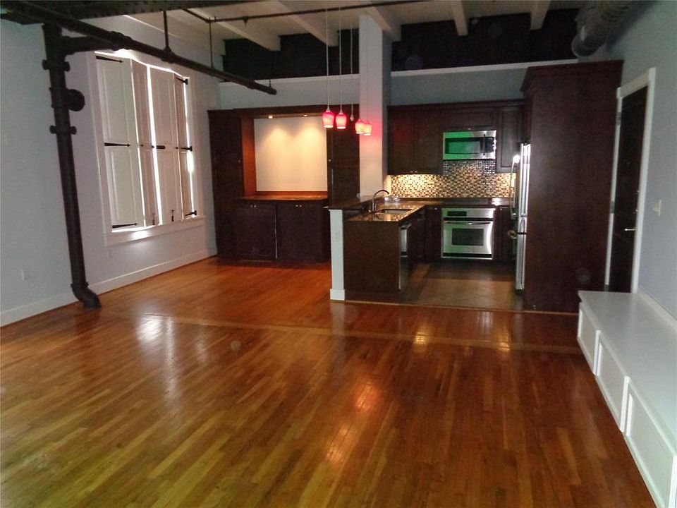 Living, kitchen and dining area for Unit 3C. Very nice wood floors. Front door to the 3rd floor hall to the right. full kitchen, including wine bar, in the background. Dining area and one of three sets of double windows overlooking 22nd Street.