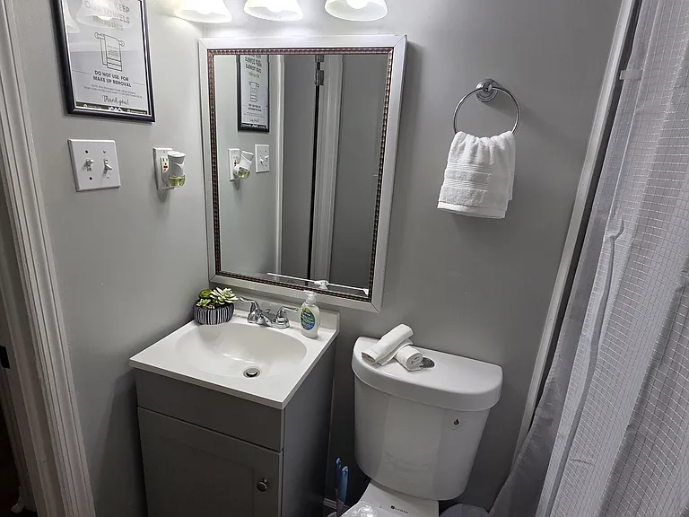 Impeccable bathroom featuring a shower, toilet, sink, and fresh towel set for your comfort.