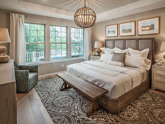 Luxury owner s suite with tray ceiling and hardwood flooring