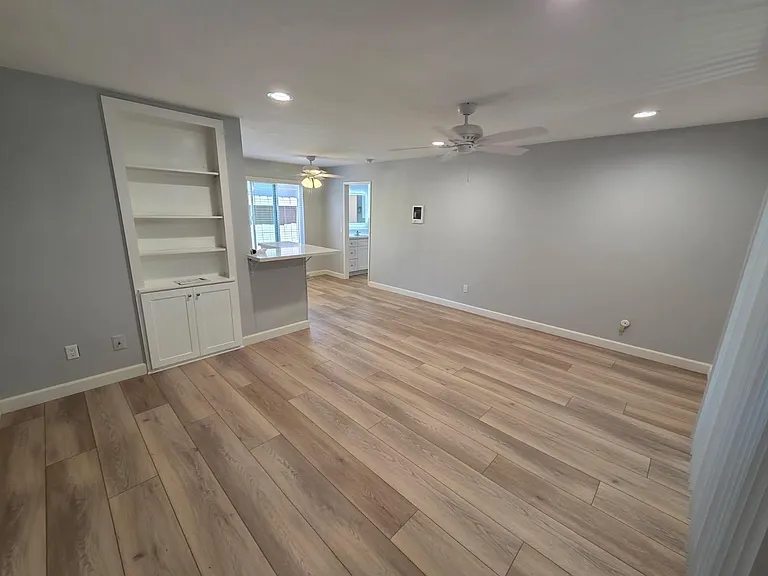 Spacious living room with a built in book shelf and new LVP flooring.
