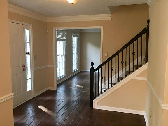 Open foyer with updated iron railing. The entire main floor has new flooring throughout.