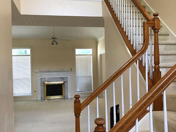 Entrance view. Living room in front. Office doorway at the top of the stairs.