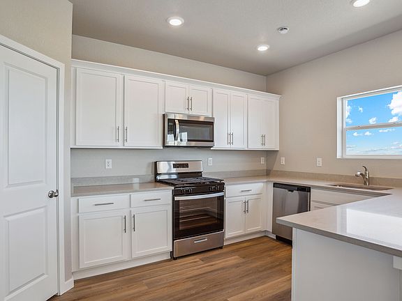 The kitchen has stainless steel appliances and white cabinets.