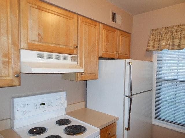 galley kitchen with newer maple cabinetry