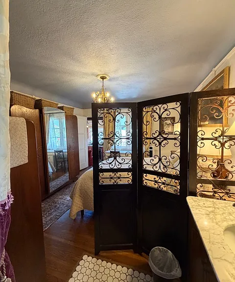 Looking from Vanity Area back into Bedroom with Chest of Drawers on the left and Large Armoire beyond