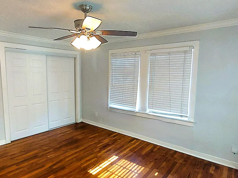 Bedroom all hardwood floors, comes with all mini-blinds and ceiling fan with lights. Also to the side is additional window unit for extra cooling. House does have central AC/heat.