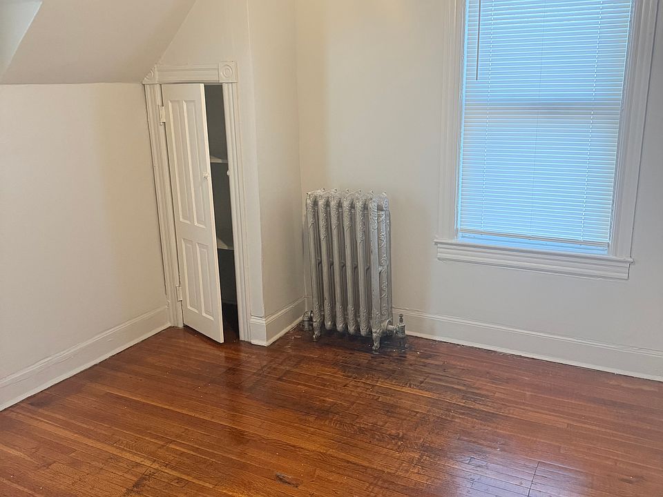 two windows in this bedroom with a small closet