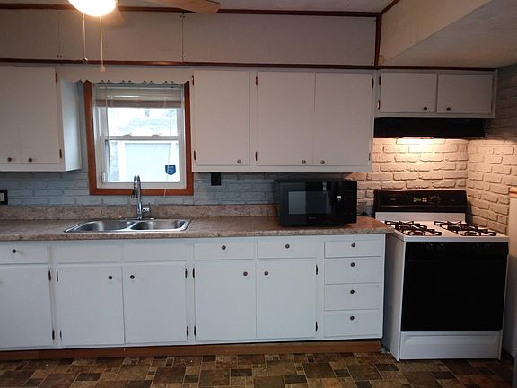 Bright white cabinet kitchen with window view to private backyard. Gas range and new microwave oven.