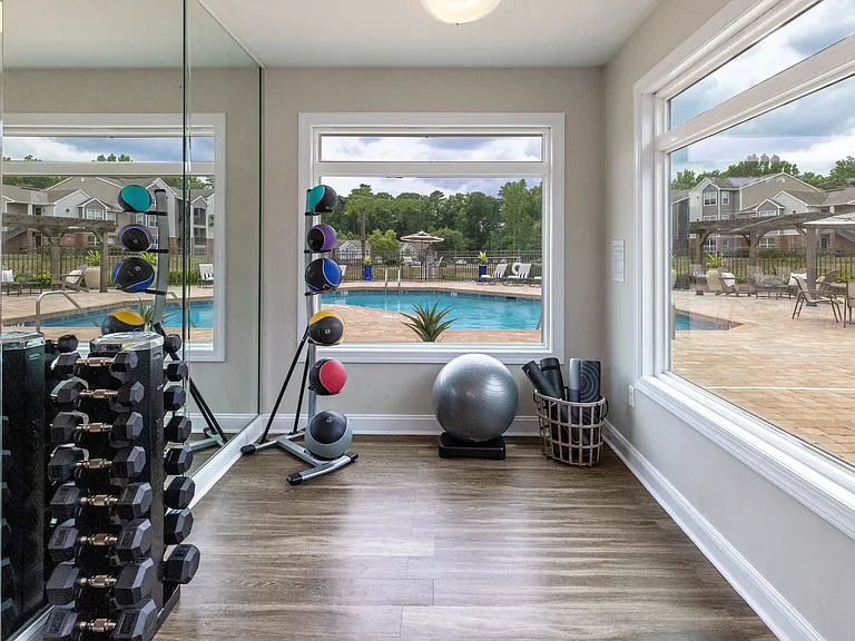 Dedicated space with panoramic pool-deck views for yoga, stretching, and free weights.