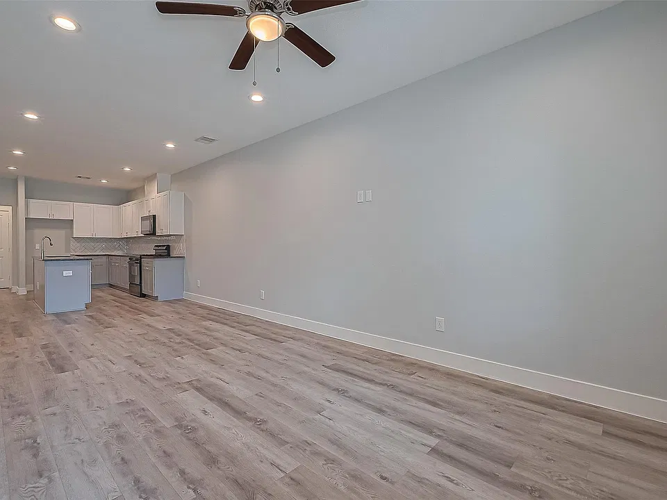 Spacious open-concept living area with ceiling fan and durable flooring