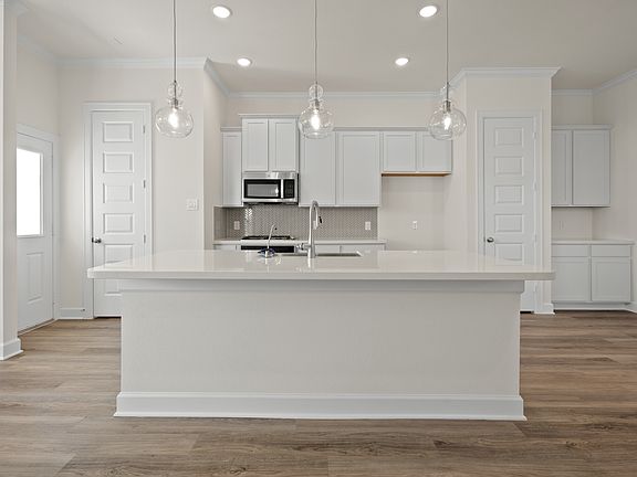 Kitchen with pendant lights vast island