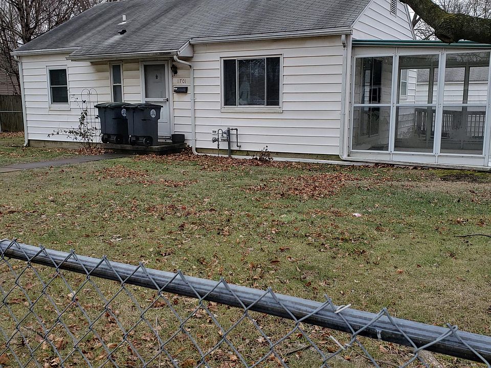 Front of house, shows sun porch. Large yard is entirely fenced.