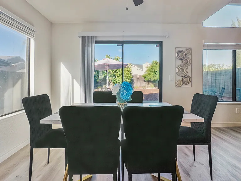 The inviting dining area features a table with seating for six, perfectly positioned next to the kitchen with serene views of the patio and backyard.