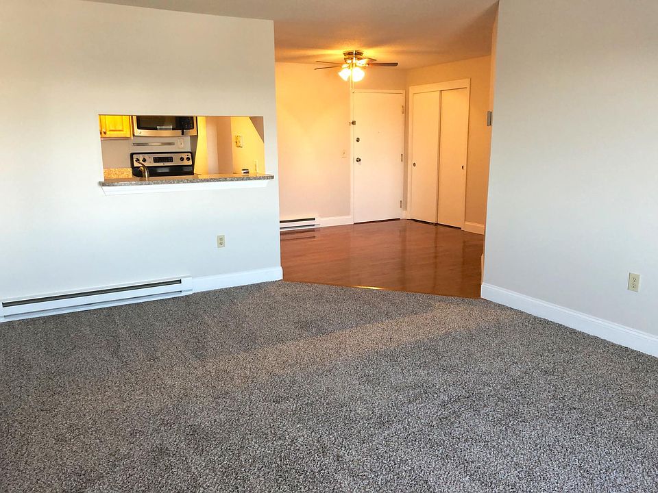 Living room, opening to kitchen with bar and dining area