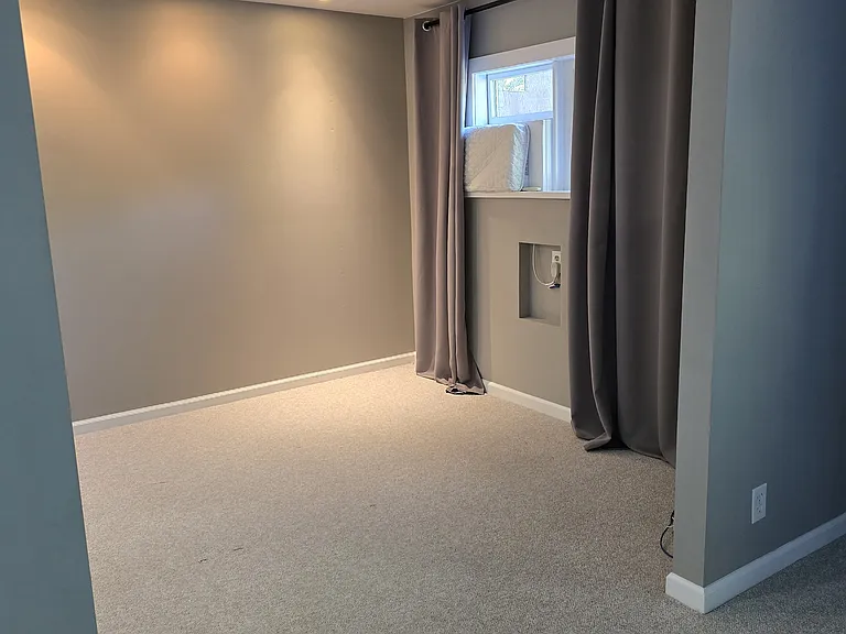 Looking into Bedroom space. Window faces north with Air conditioning unit in window. Dimmable Lighting accent lighting and florescent lighting.